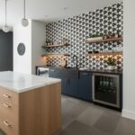 Stylish black and white geometric patterned tiles with matte finish, complementing navy blue cabinetry and wooden accents.