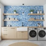 Blue glass tile backsplash, modern laundry room, wooden cabinets, open shelves, washing machine, and plants.