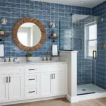 Blue glass mosaic tile backsplash in modern bathroom with walk-in shower and white vanity.