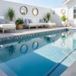 Bright and reflective glass tile backsplash enhances pool area aesthetics and durability.