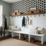 Decorative black and white geometric tile wall with wooden shelf and baskets.