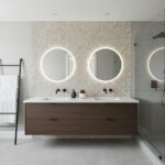 A modern bathroom featuring a double vanity with shell tile backsplash, illuminated round mirrors, and sleek fixtures.