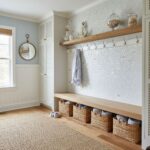 Mother of pearl shell tile used as wall decor in a bright, coastal-inspired entryway. Features a wooden shelf, baskets, and s.