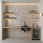 Mother of pearl shell tile backsplash with floating wooden shelves and a mini fridge.