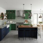 Bright, modern kitchen featuring green and navy textured tiles, stainless steel appliances, and a central island with seating.