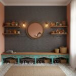 A stylish entryway featuring dark hexagon tiles, wooden shelves with decorative items, and a large round mirror.
