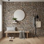 Earth-toned pebble textured tile wall with a modern design, featuring a round mirror, a wooden bench, and minimalist decor el.