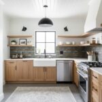 Modern kitchen with peel and stick tile backsplash, wooden cabinets, and stainless steel appliances.