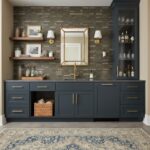 Navy blue kitchen cabinetry with peel and stick wall tile backsplash and open shelving for decor.