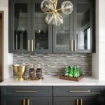 Kitchen with peel and stick wall tile, dark cabinets, and gold accents.