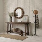Wooden console table with a round mirror, framed botanical print, and decorative items.