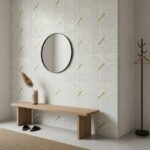 Decorative shell tile wall with mother of pearl accents and a round mirror in a modern entryway.