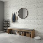 Decorative shell tile wall with mother of pearl accents and a round mirror in a modern entryway.