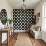 Black and white floral wallpaper, textured wooden furniture, and woven accents create a warm, inviting space.