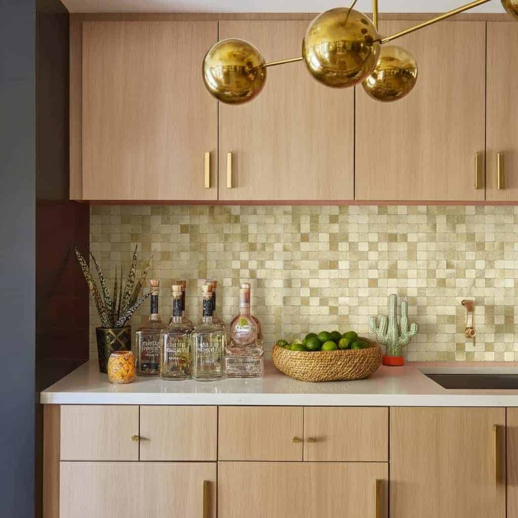 Gold pendant light over kitchen with peel and stick wall tile backsplash.