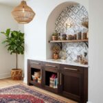 Bright kitchen featuring peel and stick wall tile backsplash with geometric pattern. Elegant dark cabinetry and decorative ac.