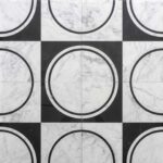 White marble tile with black and white circular pattern.