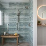 Shower featuring a blue glass tile backsplash with mosaic pattern and modern fixtures, creating a sleek and stylish bathroom.