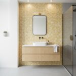 Modern bathroom with a wall covered in mother of pearl shell tiles, creating a shimmering, elegant backdrop.