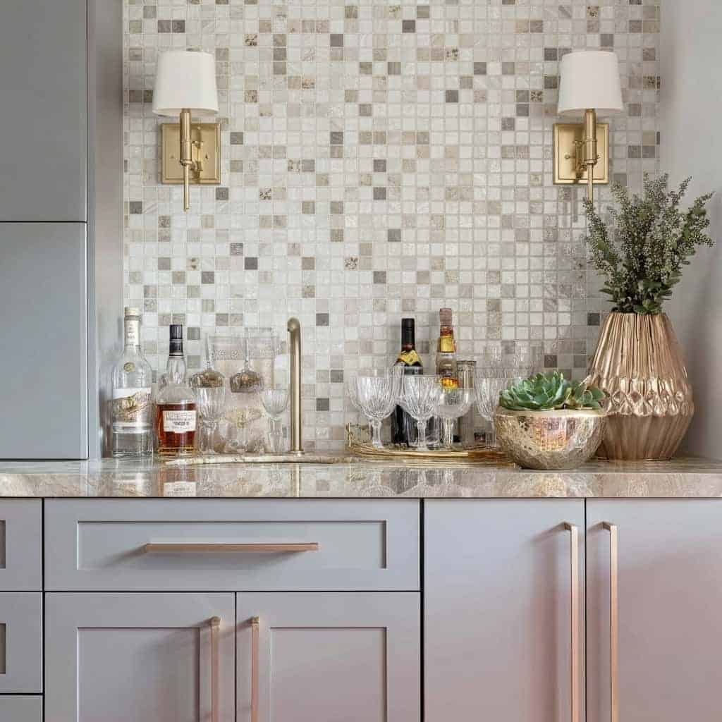 A stylish kitchen with a glass tile backsplash, featuring mosaic glass tiles, a marble countertop, and decorative elements li.