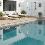 Outdoor pool with glass tile backsplash and stylish patio furniture.