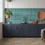 Glass tile backsplash in shades of blue behind kitchen sink.