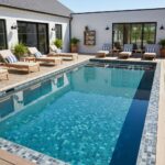 Beautiful blue glass tile backsplash enhances the pool's aesthetic appeal.