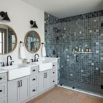 Bathroom featuring glass tile backsplash, dual sinks, and a spacious walk-in shower with glass mosaic tiles.