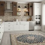 Modern kitchen with peel and stick tile backsplash, white cabinets, and stainless steel appliances.