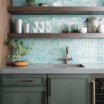 Bright glass mosaic tile backsplash behind kitchen sink and shelves.