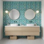 Bathroom featuring a glass tile backsplash, double sinks, and contemporary decor.