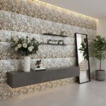 A stylish interior featuring a wall decorated with mother of pearl shell tiles, complemented by a large mirror, potted plants.