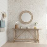 Decorative shell tile wall with a round mirror, lamp, and plants in a modern interior setting.