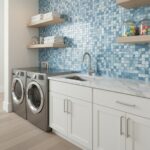 Modern laundry room featuring a blue seashell tile backsplash with a white countertop and cabinetry.