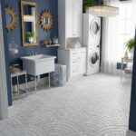 Bright laundry space featuring white cabinets, stacked washer and dryer, and decorative gold accents.