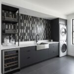 Image of peel and stick tile backsplash in a contemporary laundry room with dark cabinetry and stacked washer and dryer.