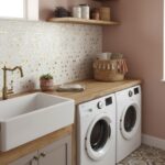 Up of a laundry room wall with mother of pearl shell tile behind a sink and washing machines.