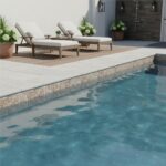 A modern outdoor pool area featuring glass mosaic tiles, lounge chairs, and potted plants for a relaxing ambiance.