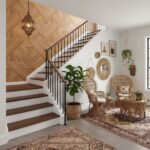 Wooden herringbone tile wall with staircase and cozy seating area, natural decor accents, and a patterned rug.