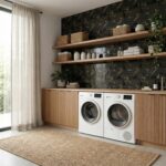 Bright laundry room with black patterned tile wall, wooden cabinetry, and open shelves holding baskets and decor.