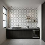 Black and white geometric patterned tile wall in a modern kitchen setting.