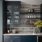 Glass tile backsplash with sleek design and dark tones.