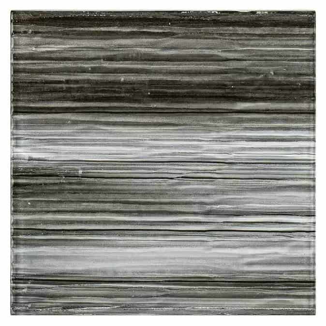 Up of a glass mosaic tile backsplash featuring horizontal striped patterns in shades of gray and black.