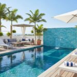 Poolside glass mosaic tile backsplash with water feature.