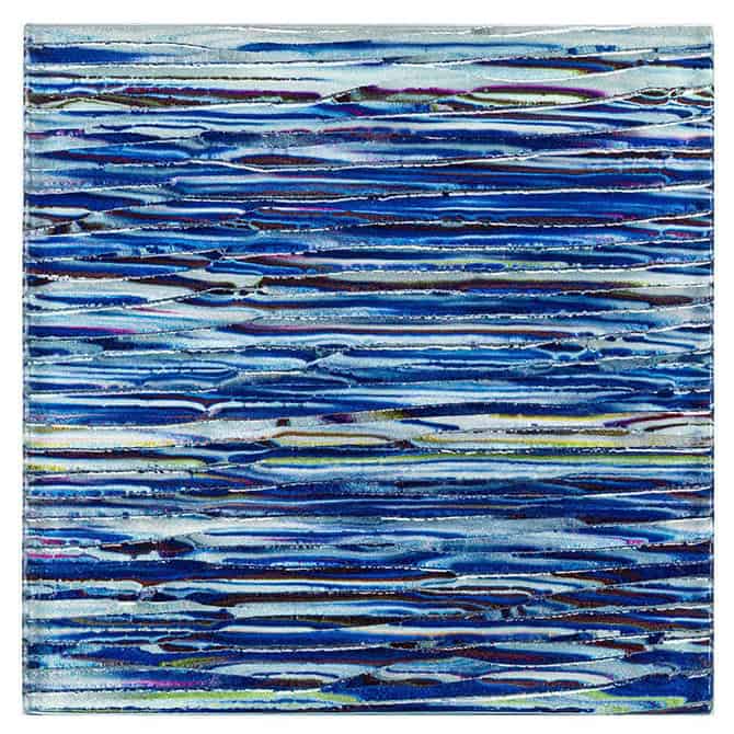 Glass mosaic tile with blue tones, ideal for backsplashes and pools. Features a textured, layered design with vibrant blue sh.