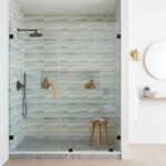 Glass tile backsplash in modern shower.