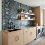 Glass tile backsplash with blue and gray mosaic tiles behind laundry area.