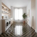 Bright laundry room with black and gold patterned hexagon tiles, white walls, and natural light from large window.
