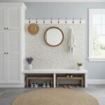 Mother of pearl shell tile wall decor with a round mirror and hooks in a bright, modern entryway. Perfect for adding a coasta.
