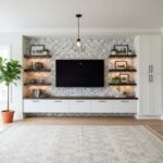 Modern living room with peel and stick wall tiles behind TV, featuring open shelves and decorative accents.